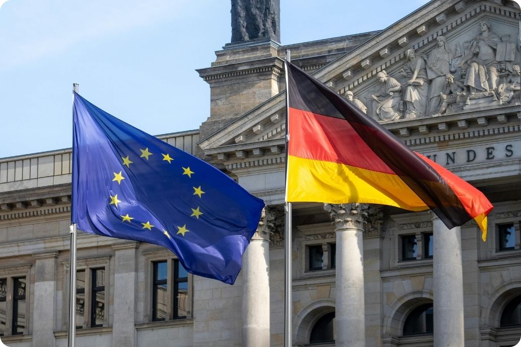Flagge der EU und von Deutschland vor einer Behörde